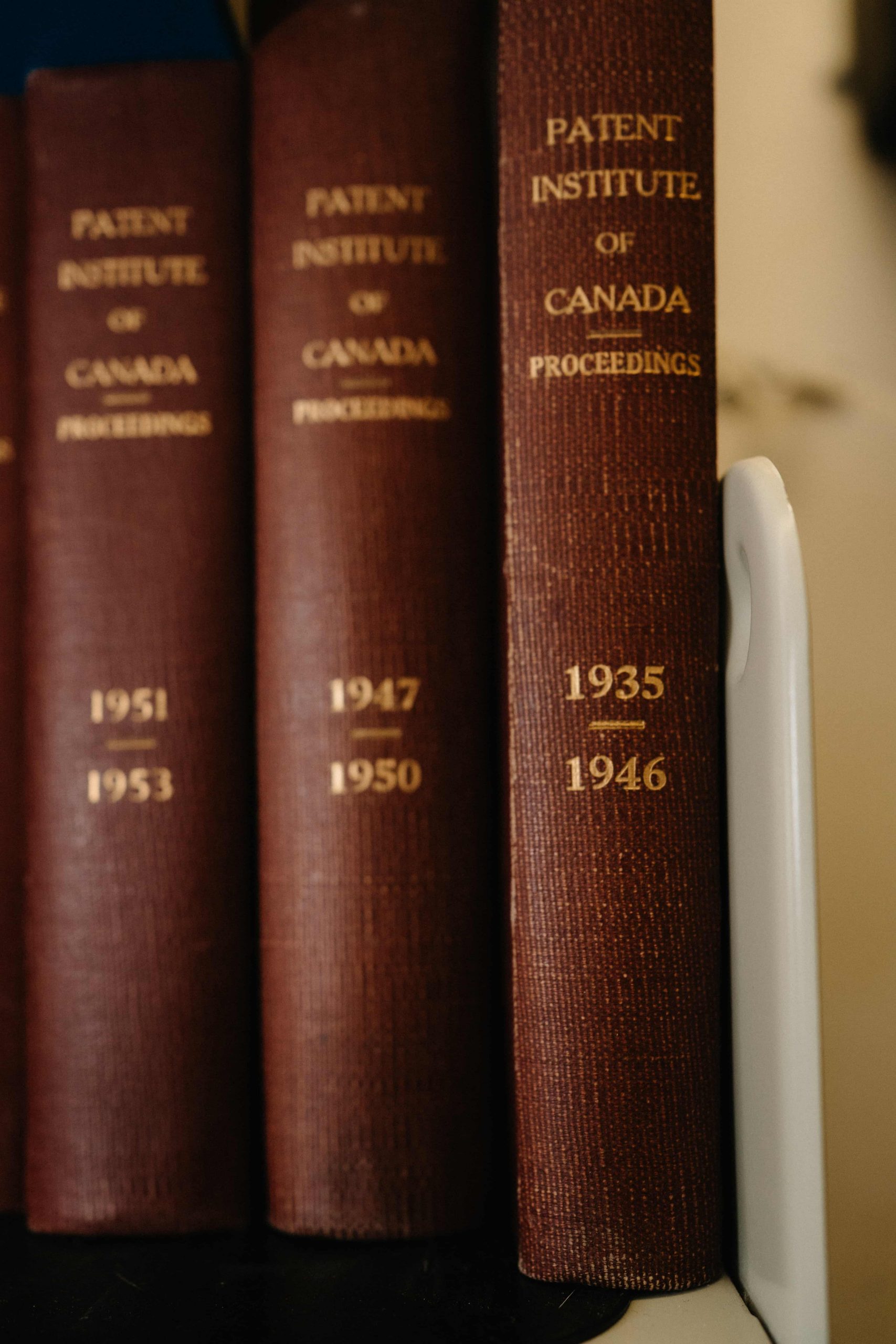 Trois dos de livres sur une étagère, chacun intitulé « Patent Institute of Canada Proceedings ».